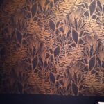 Mur avec papier peint végétal foncé ambiance chaleureuse