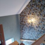 Escalier avec papier peint texturé et éclairage mural