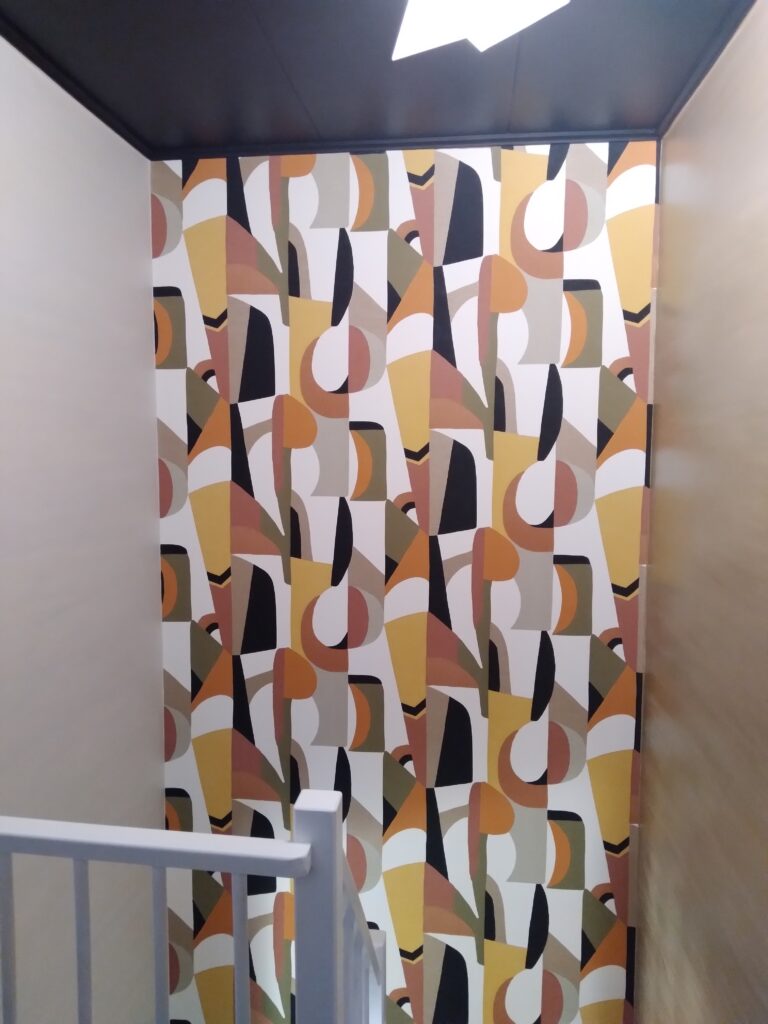 Escalier avec papier peint géométrique et meuble intégré