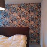 Chambre avec papier peint floral et décoration murale