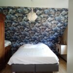Chambre rénovée avec papier peint motif nature