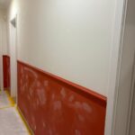 Couloir avec soubassement rouge et papier peint